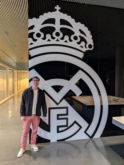 Standing in front of an enormous Real Madrid crest on a dark wall