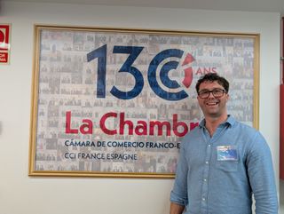 Standing in front of the Spanish and French Chamber of Commerce wall sign
