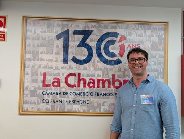 Standing in front of the Spanish and French Chamber of Commerce wall sign