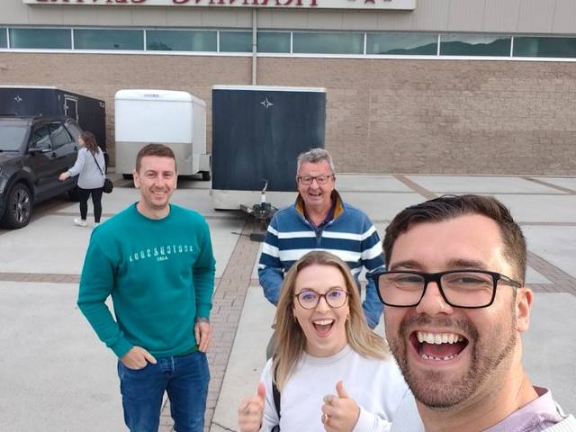 Dean taking a selfie with three friends outside the Okanagan Hockey Training Centre in Canada, everyone laughing and giving thumbs up.